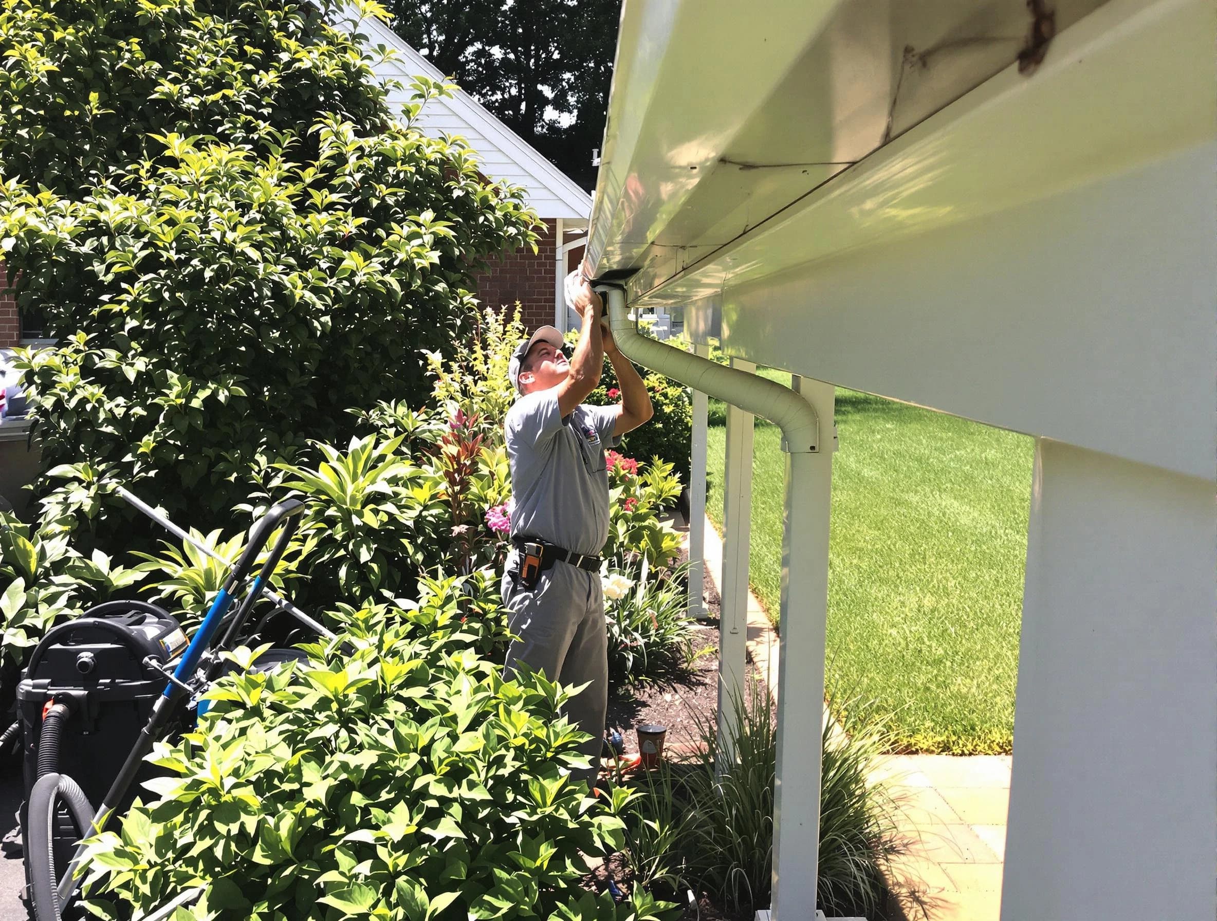 Technician flushing a blockage from a downspout in Streetsboro, OH